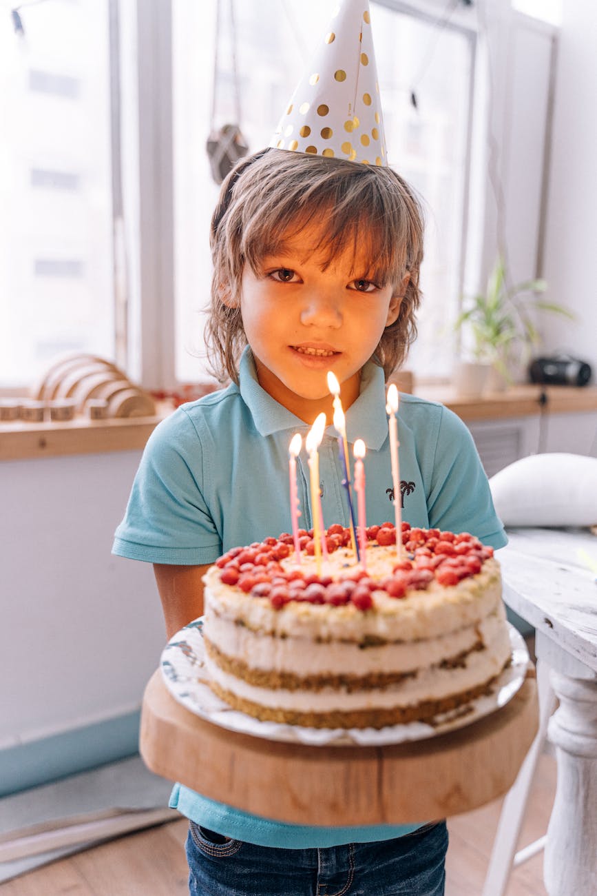 a boy holding a birthday cake